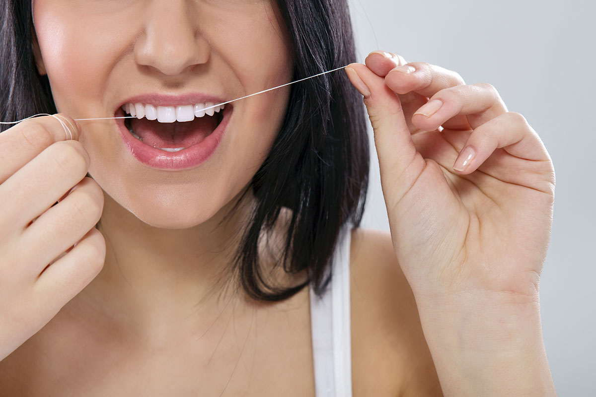 benefits of flossing daily woman flossing after leaning the benefits of flossing daily