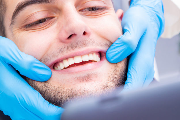 causes of receding gums man thinking about causes of receding gums