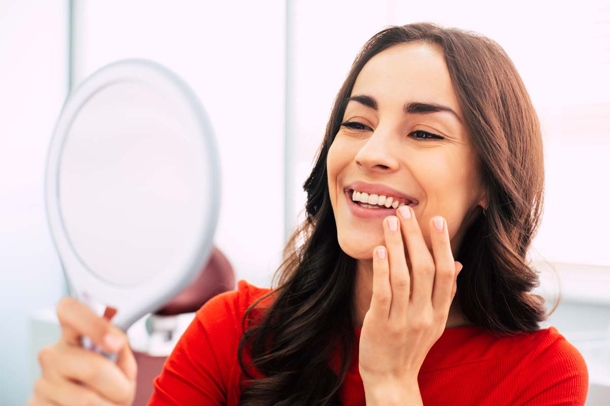 woman looking at her replacement teeth