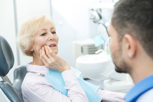 older woman at dentist when a tooth falls out