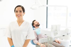 dentist with patient in background getting preventative dentistry