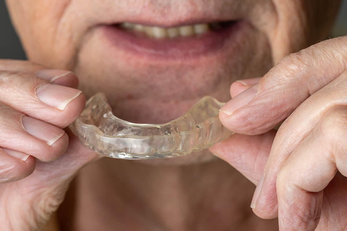 do-you-need-a-night-guard individual putting in a nightguard